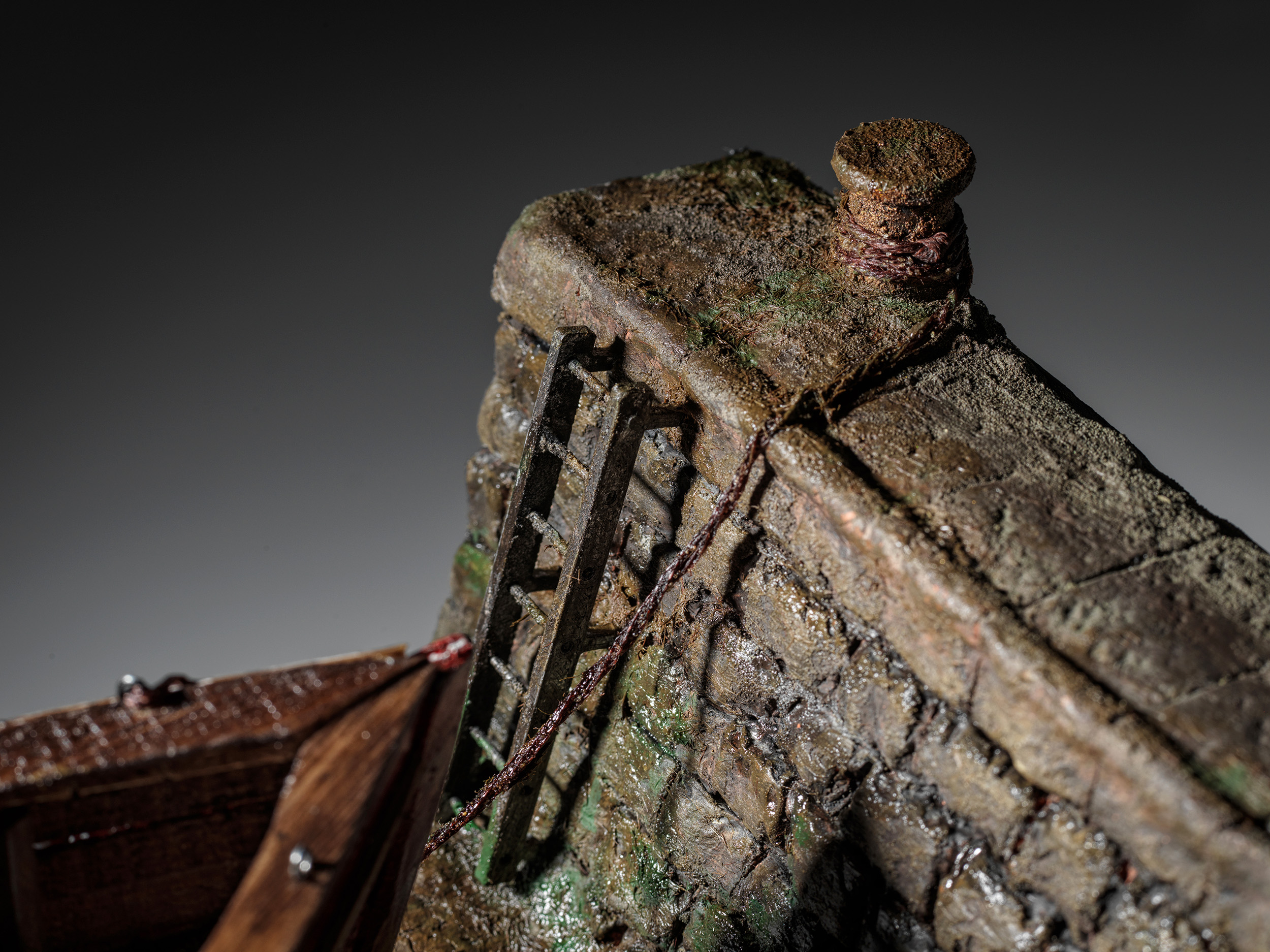 Weathered harbour ladder, stonework and mooring bollard beside Mollie